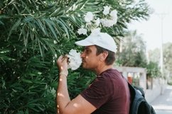 young candid man traveler enjoys the scent of a flowers Product Image 1