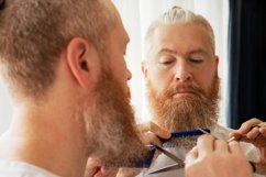 Handsome mid adult man cutting his beard by himself Product Image 1