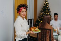 A swarthy woman is carrying a festive turkey to her friends Product Image 1