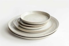 Stack of rustic ceramic plates with speckled glaze on white Product Image 1