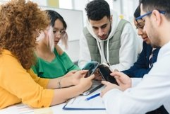 Diverse multinational team take a break using phones Product Image 1