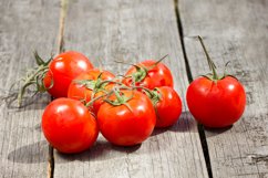 group of red tomatoes on a wooden table Product Image 1