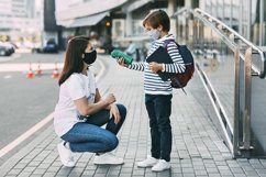 Schoolboy and mother wearing medical masks during a pandemic Product Image 1