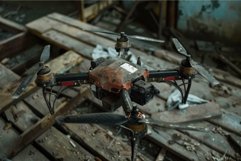 Broken dusty drone lying on a wooden floor Product Image 1