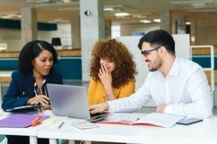 African american woman talking to coworkers in bright office Product Image 1