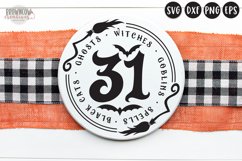 31 in spooky text with two witch brooms shown on a round wooden sign
