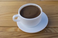 White mug with black coffee standing on a wooden table Product Image 1