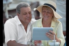 Cheerful mature couple with touch pad outdoor Product Image 1