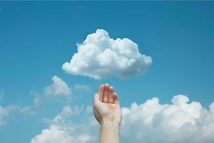 Hand reaching for cloud in blue sky Product Image 1