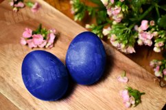 Blue Easter eggs on a wooden table with pink flowers Product Image 1