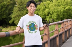 Digital PNG design featuring a hand-painted illustration of planet Earth with green continents and blue oceans, encircled by vibrant pink, orange, and purple flowers with leafy accents. The text &quot;Earth Day&quot; appears above and &quot;Go Planet!