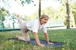 Sporty woman practicing yoga lesson, workout in summer park Product Image 1