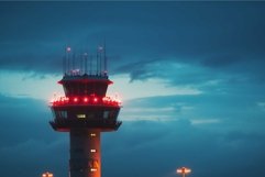 Air traffic control tower guiding airplanes at dusk with dra Product Image 1