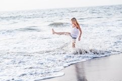 Attractive happy mature tourist woman jumping on sand beach. Product Image 1
