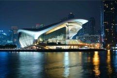 Modern opera house with glowing lights at night reflecting i Product Image 1