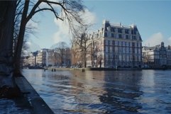 Canal reflecting sunlight with traditional dutch houses in a Product Image 1
