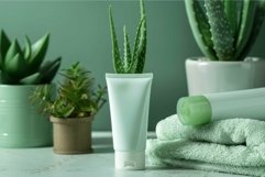 Cosmetic tube standing near aloe vera and a towel on grey ta Product Image 1