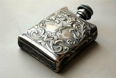 Antique engraved silver flask is lying on a table Product Image 1