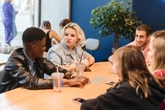 A young woman enjoys socializing with multinational friends Product Image 1