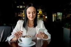 Girl Drinking Coffee in Cafe. Beauty Woman with mobile phone Product Image 1