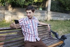 Caucasian man sitting with phone Product Image 1