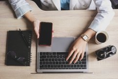 Hand of business woman typing on keyboard while holds phone Product Image 1