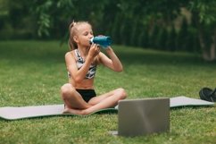 A girl is engaged in online fitness near her house on a rug Product Image 1