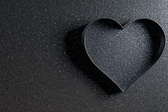 A heart-shaped cookie cutter on a dark textured surface Product Image 1