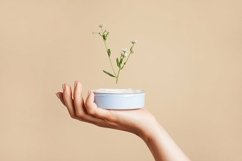 Female hand holding jar with cosmetic cream with flower Product Image 1