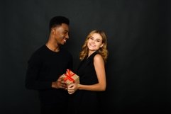 A young man gives his Caucasian girlfriend a present Product Image 1