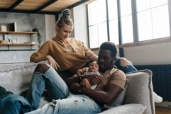 Smiling mother and father holding their newborn baby son Product Image 1