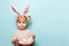 A little girl with bunny ears on her head holds easter eggs Product Image 1