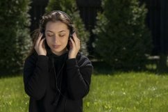 Attractive brunette in black hoodie listening music Product Image 1