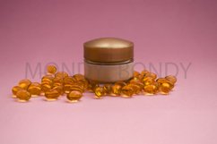 Bottle of cream with oil capsules on a pink background. Product Image 1