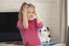 Emotional portrait of schoolgirl studying homework Product Image 1
