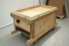 Large wooden crate with wheels standing on concrete floor Product Image 1