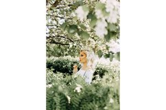 Beautiful young blonde girl in blooming Apple orchard. Product Image 1