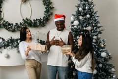 Black man receiving a Christmas present from female friends Product Image 1