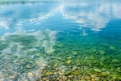 Crystal clear lake water over smooth pebbles Product Image 1
