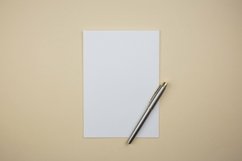 Paper sheet mockup with a pen, office place flat lay . Product Image 1