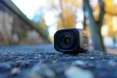 Small action camera standing on stone surface outdoors Product Image 1