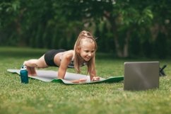 A girl is engaged in online fitness near her house on a rug Product Image 1