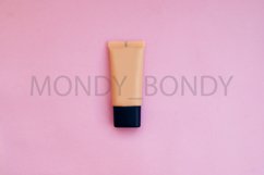 Beige flat bottle of foundation on a pink background. Product Image 1