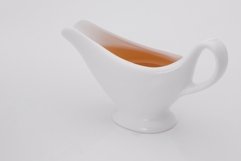 Sauce in white gravy boat on a white background Product Image 1