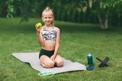 A girl is engaged in online fitness near her house on a rug Product Image 1