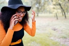 Black woman talking on phone outdoors in the park Product Image 1