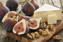 Figs, cheese and walnuts lying on wooden cutting board Product Image 1
