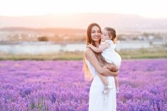 Beautiful woman holding little baby girl in lavender field Product Image 1