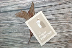 A5 paper mockup with dry leaves on wooden background Product Image 2
