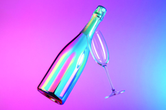 An iridescent champagne bottle with a flute glass on a pink Product Image 1